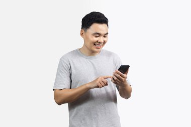 Gülümseme portresi mutlu adam beyaz arka planda duran akıllı telefonu işaret ediyor.