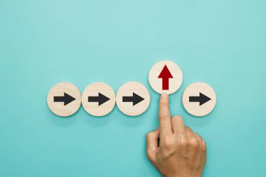 İş akışı, olağanüstü liderlik, yaratıcı fikir ve yenilik kavramı. Parmakların yukarı doğru uzanan kırmızı okları işaret eden siyah okun zıt yönüne doğru itmesi