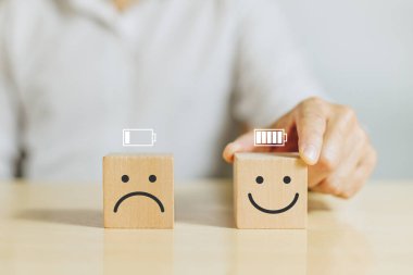 Çalışma motivasyonu, Batarya, Enerji, Çalışan mutluluğu ve pozitif tutum. Elle tutulur ahşap, gülen surat ifadesi ve ofiste tam teşekküllü enerji pili var.