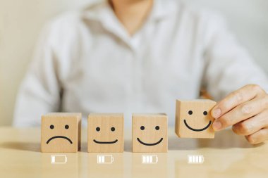 Çalışma motivasyonu, Batarya, Enerji, Çalışan mutluluğu ve pozitif tutum. Elle tutulur ahşap, gülen surat ifadesi ve ofiste tam teşekküllü enerji pili var.