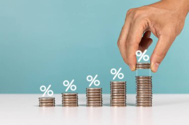 Finansal, faiz oranı ve kar payı, hisse senetleri ve faiz oranı. Ofiste madeni para ve sikkeleri elinde tutan bir adam var.