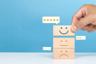 Hizmet derecesi, memnuniyet ve olumlu geri bildirim kavramı. Gülümsemeyi seçen bir adamın yüz ifadesi beş yıldız vermek en yüksek tatmin seviyesini gösterir.