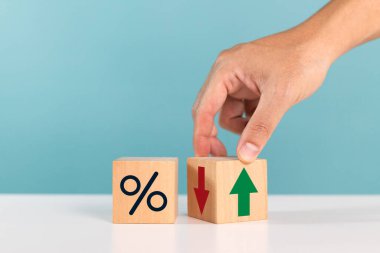 Finansal, hisse senedi, faiz oranı ve GSYİH 'da yüzde değişiklik. Faiz oranı, sıralama, finansal hisse senetleri ve GSYİH 'daki yüzde değişikliklerle birlikte tahta bloğu ters çeviren bir adam.