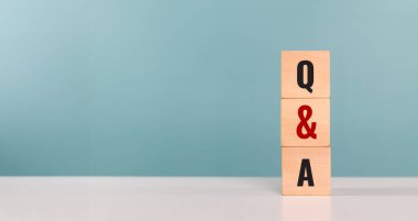 Soru-Cevap, SSS konsepti. Q ve A yazılı tahta küp ofisteki masada duruyor. Sorular ve cevaplar