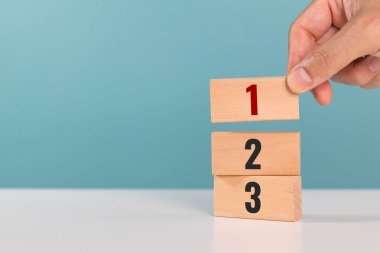 Görev önceliği ve yönetim kavramı. Faaliyetlerin önceliği. Elle yerleştirilen tahta küplerle bir, iki ve üç numara