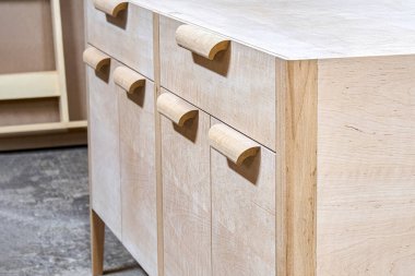 Chest of drawers made of solid alder in process of production at workshop close up view. Creation of modern domestic furniture for bedroom interior clipart
