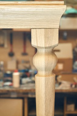 Ahşap yemek masası, sağlam meşeden yapılmış bacağı ve metal çerçeve oluşturma süreci atölyede çok yakın çekim görüntüsü.