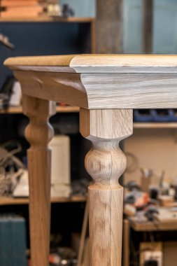 Ahşap yemek masası, sağlam meşeden yapılmış bacağı ve metal çerçeve oluşturma süreci atölyede yakın görüş.