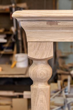 Ahşap yemek masası, sağlam meşeden yapılmış bacağı ve metal çerçeve oluşturma süreci atölyede çok yakın çekim görüntüsü.