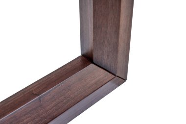 Beyaz arka planda saf cevizden yapılmış ahşap masa çerçevesi. Döşeme üzerindeki kalasların açısal birleşimi yakın plan