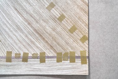 Jointed veneer with tape into canvas for table top of dining table with geometric pattern on workbench in workshop upper close view clipart