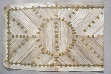 Jointed veneer with tape into a large canvas for table top of dining table with geometric pattern on workbench in workshop upper view clipart