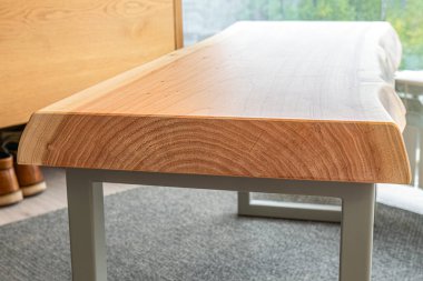 Canlı ahşap kaplamalı bank ve modern tasarımda gri metal bacaklar oturma odasında, pencerenin yanında halı kaplı zemin ile.