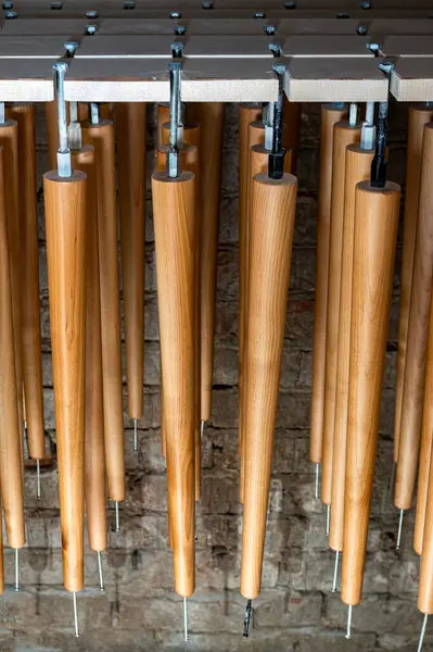 Yeni ahşap mobilya koleksiyonu. Ahşap atölyeye yakın görüntüde vernik uyguladıktan sonra bacaklar kuruyor.