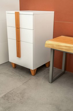 Canlı kenar ahşap bank, gri metal bacaklar ve beyaz çekmeceler, tahta saplı ve bacakları banyoda.