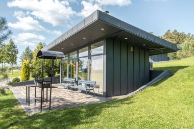 Yazlık otelin bahçesinde cam duvarları ve barbekü alanı olan bir misafir evi. Bahçesinde ızgara ekipmanı olan bir kafe. Dinlenecek yer