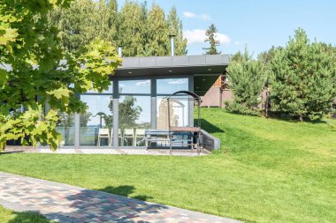 Yazlık otelin bahçesinde cam duvarları ve barbekü alanı olan bir misafir evi. Bahçesinde ızgara ekipmanı olan bir kafe. Dinlenecek yer