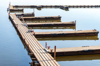 Sakin nehirdeki balıkçı tekneleri için boş ahşap duba iskelesi. Uzun rıhtımlarda demirleyecek yeri olan birkaç kısa köprü. Nehir manzarası