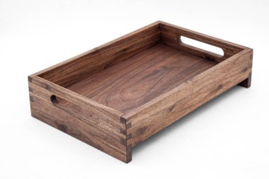 Katı ceviz ağacı ahşap tepsisi, dovetail eklemleri ve kenarlarında kesme sapları var. Beyaz arka planda yakın plan görüntüsü var.