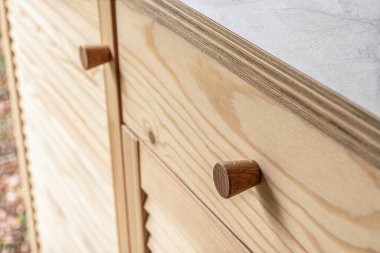 Tahta kapı kollu, ahşap kapı kolları yakın plan. Açık mutfak kapıları açık çam ağacından ve doğal tahıl desenli.