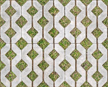 Geometrik beton kaldırım taşları, çimen dolu boşluklar, düz bir yüzeyde tekrar tekrar dizilmiş. Kusursuz doku