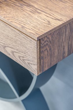 Gösterişli ahşap konsol masası zengin bir ahşap kaplama ve kendine özgü gri lekeli bükülmüş bacaklar içerir.