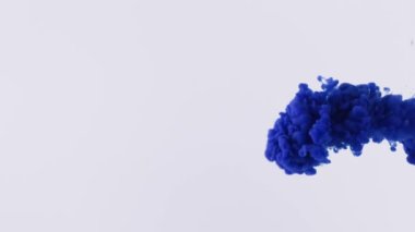 Mavi sıvı mürekkep jeti şeffaf suya yayılır ve ilginç desenler yaratır. Mavi boya sıçrar ve harika bir şekil alır. Süper yavaş çekim.