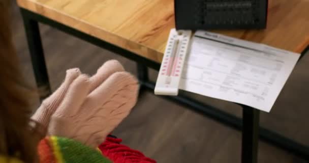 女人们用手套和暖气暖身检查不断增加的账单 并检查公寓的温度 Lady探索每个月的社区付款 — 图库视频影像