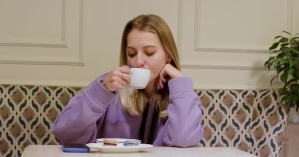 Blondine Vrouw Drinkt Koffie Kijkend Smartphone Aan Tafel Vrolijke Dame — Stockvideo