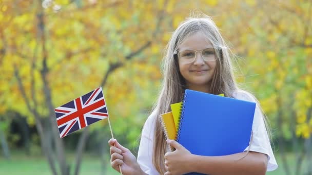 Adolescente Rubia Sostiene Bandera Británica Copybooks Parque Otoño Adolescente Pelo — Vídeos de Stock