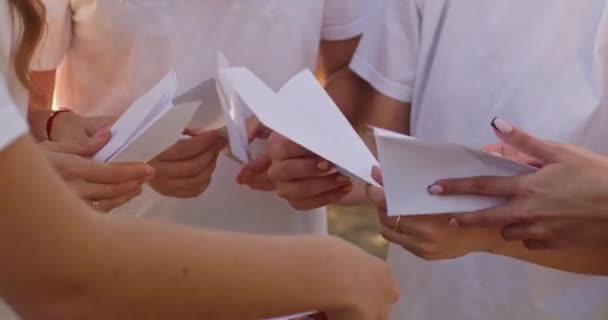 Tonårstjejer Håller Pappersflygplan Och Förbereder Sig För Lansering Stadsparken Grupp — Stockvideo