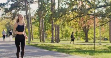 Kısa saçlı kadın koşmayı bırakıyor. Şehir parkında bacağı ağrıyor. Genç sporcu kadın diz ağrısını durdurmaya çalışıyor ve koşuya ara vermeye karar veriyor.