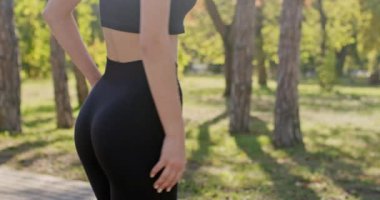 Genç bir kadın uzun süredir şehir parkında koşan güzel, sportif bir vücut gösteriyor. Siyah takım elbiseli kadın harika bir vücut ölçüsü sergiliyor.