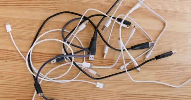 手把一堆堆Usb线扔在木制桌子上 近距离向上看 不同插头的电缆束 车间中的适配器工具包 — 图库视频影像