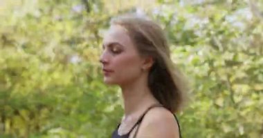 Güz parkında koşan kısa saçlı genç bir kadın. Siyah spor takım elbiseli sıska bayan doğayla bütünleşmeyi seviyor.