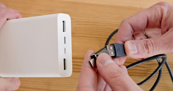 人们把微型Usb适配器安装在木桌上方的电源库上 连接充电装置和电源 — 图库视频影像