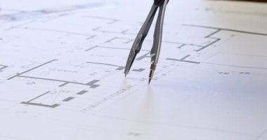 Yetenekli kişi kurşun çekirdekli bölücüler kullanarak kağıt inşa projesine daire çizer. Sarı defter ve hesap makinesi taslak üzerinde