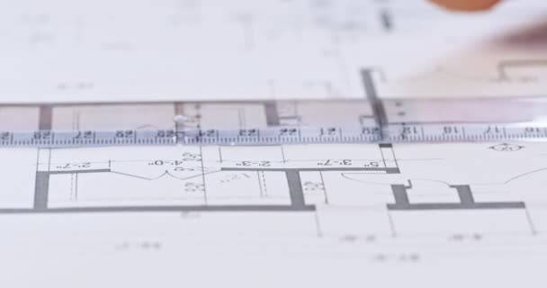 人の手は定規及び鉛の鉛筆を使用して長さの測定をし 線を引く 表面に横たわる建物プロジェクトに描かれた熟練した手 — ストック動画