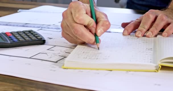 Mérnök Ceruzával Jegyzetel Legújabb Épületmódosításokról Sárga Jegyzetfüzetben Számológép Vonalzó Fekszik — Stock videók