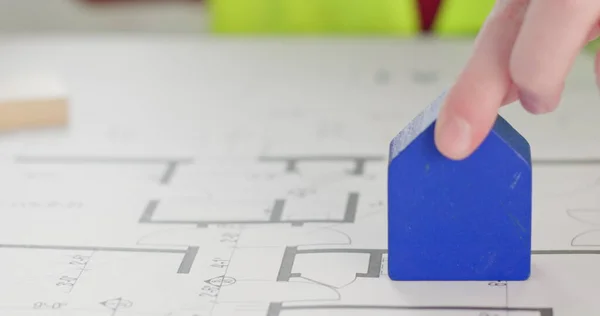 Anaokulu müteahhidi rolünü taklit ediyor ve apartmanın düzenine mavi yapı blokları koyuyor. Çocuk yapıcıyı yavaş çekimde merkeze yaklaştırıyor