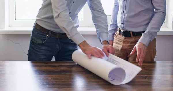 Müteahhitler ferah ışıklı ofis odasında buluşurlar. İşçi kâğıt rulo hazırlar. İşçiler inşaatın tasarımı hakkında canlı tartışmalara başlıyorlar.