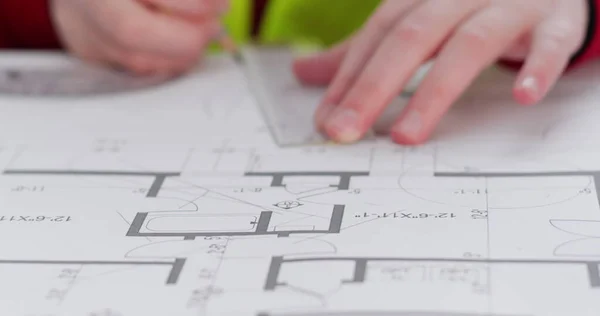 Liseli kız mimar rolünü taklit eder ve cetvelle düz bir düzen çizer. Küçük kız daire kapanışında açıölçer ve kalemlerle daire çiziyor.