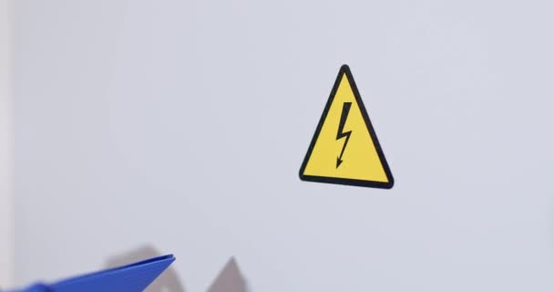 Opravář Gumových Rukavicích Ukazuje Ukazováčkem Elektrickou Značku Žlutý Varovný Štítek — Stock video