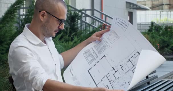 Designer Freelancer Estuda Planos Apartamento Empreendedor Olhando Para Planos Apartamento — Vídeo de Stock