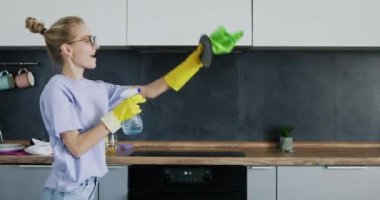 Sarışın kadın mutfakta dans ediyor. Geniş bir dairede sofra takımını siliyor. Günlük giysiler içinde ev hanımı evde bulaşık yıkamayı sever.