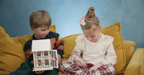 プリスクールは人形ハウスやおもちゃのろうそくで遊んでいます お正月のお祝いのために人形のための広々としたアパートを飾りたい — ストック動画
