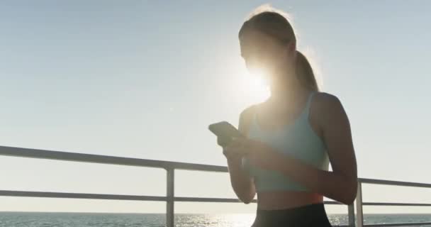 운동복을 해변에서 휴식을 선수는 메시지를 작성하는 실행에서 휴식을 취합니다 — 비디오