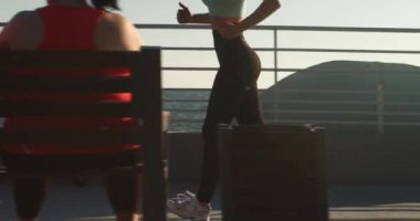 Genç bayan sporcu güne şehrin sahil şeridinde uzun bir koşuyla başlıyor. Kadın koşucu gün doğumunda deniz suyunun önünden uzun süre koşar.