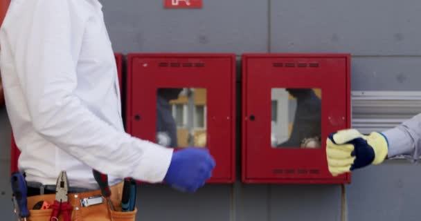 Workers Fist Bump Standing Next Fire Safety Boxes Construction Site — Stock Video