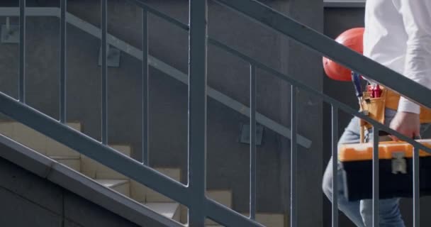 빌더는 자신감 건물의 어두운 계단을 상자와 헬멧을 올라갑니다 경험이 풍부한 — 비디오